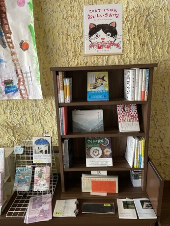 小さい本棚。
『魔女だったかもしれないわたし』『助けてと言える社会へ』『クルドの食卓』などが並んでいる