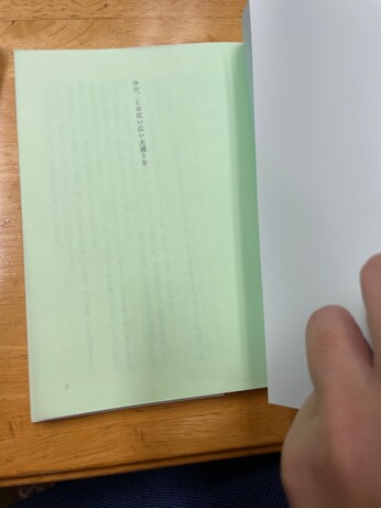 表紙をめくったところ。薄緑色のトレーシングペーパーに、扉の「ゆけ、この広い広い大通りを」の文字が透けている。
